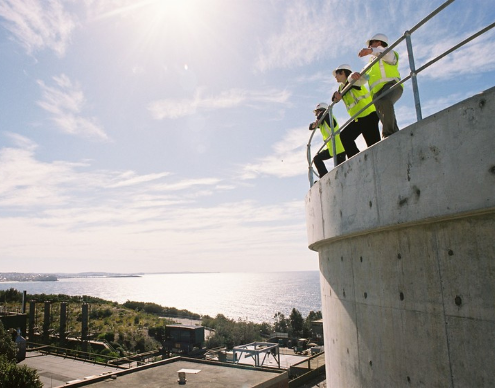 Confluence workers standing on cement tank overlooking view