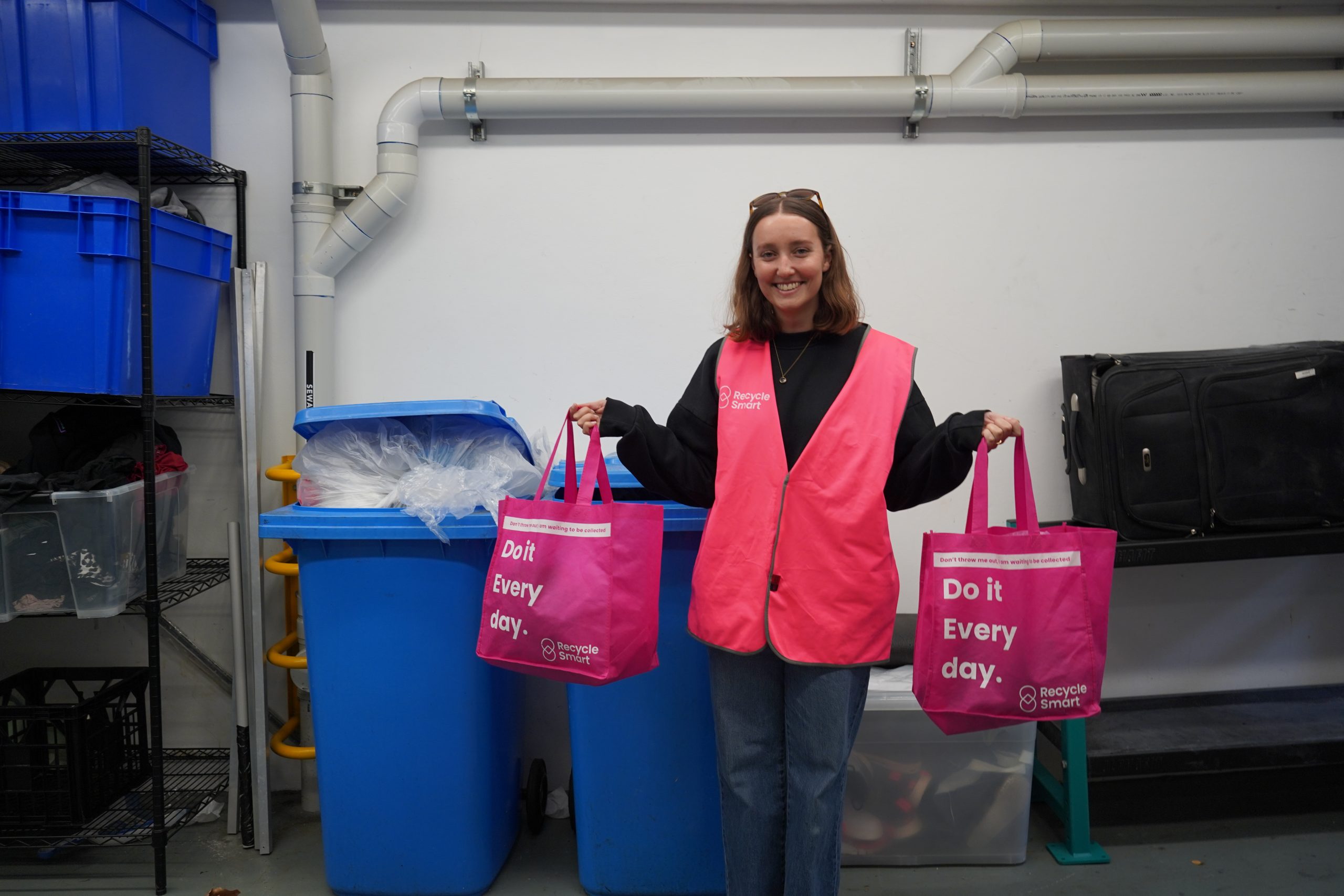 Female in pink safety vest holding pink bags of soft plastic